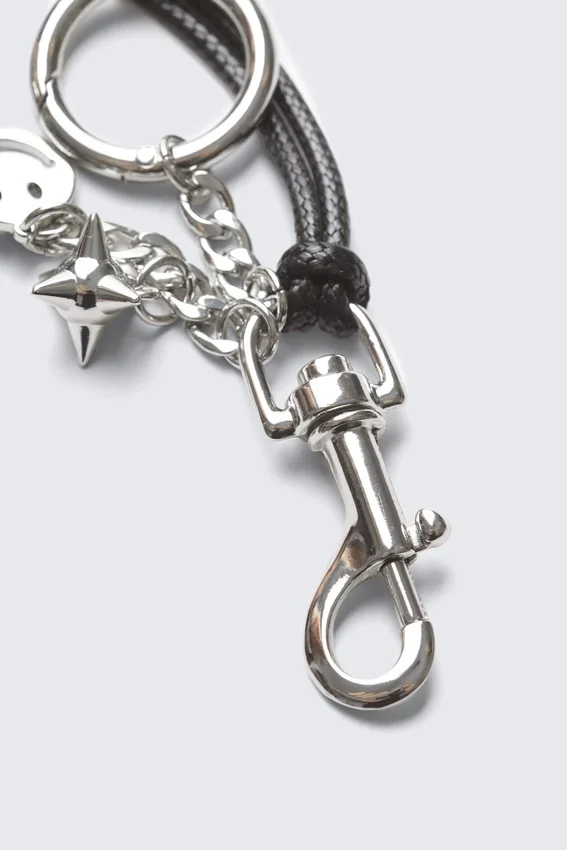 Schlüsselanhänger mit mehreren Anhängern – Metall/schwarze Schnur Schlüsselanhänger mit mehreren Anhängern – Metall/schwarze Schnur